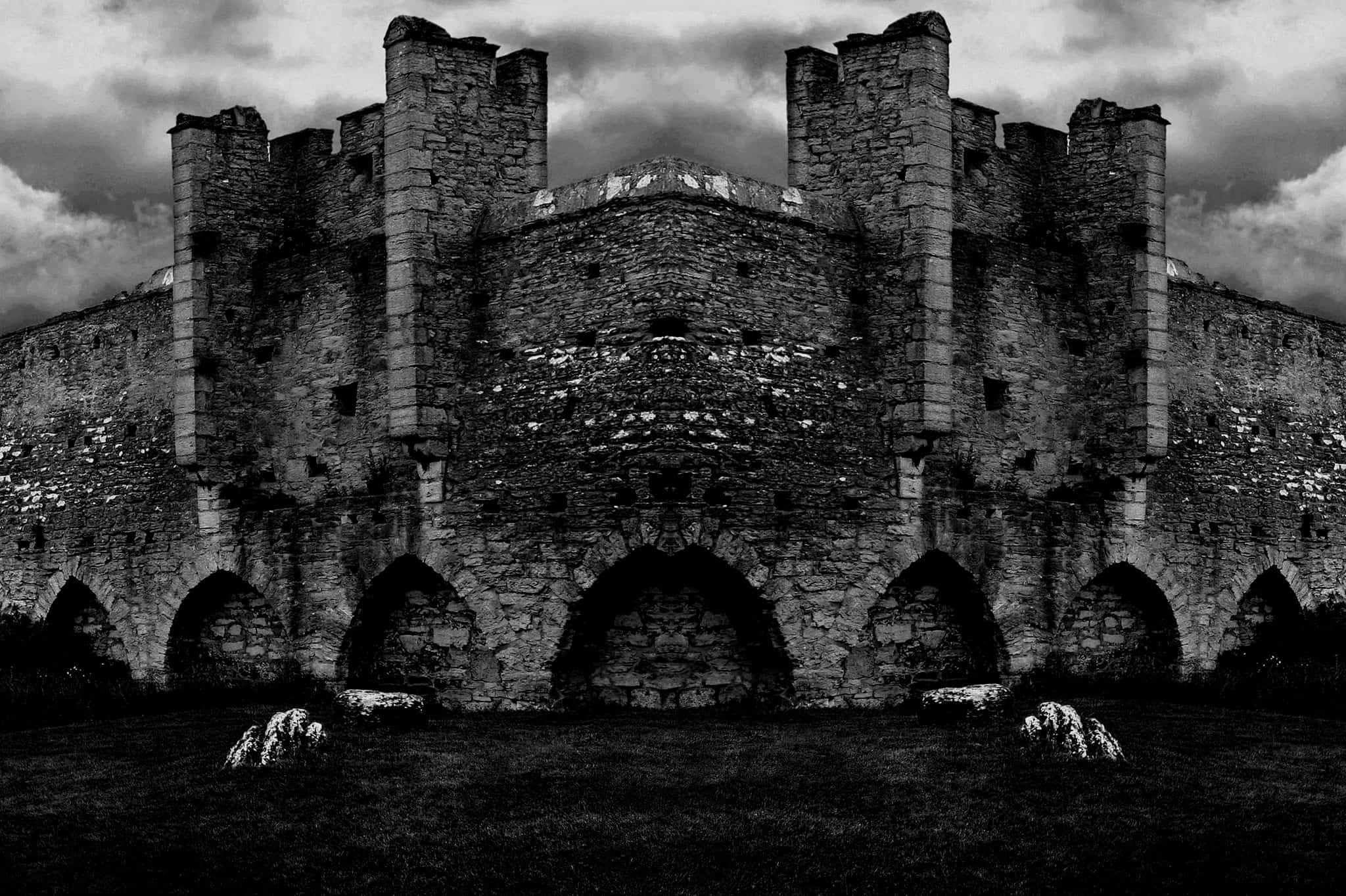 Exterior of a castle wall, black and white.