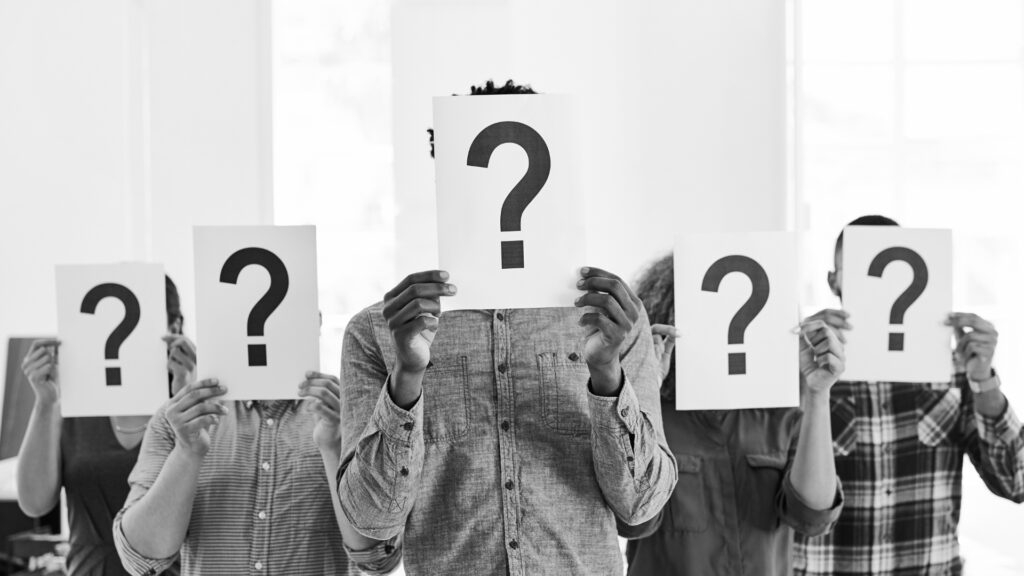 5 people holding question mark cards over their faces